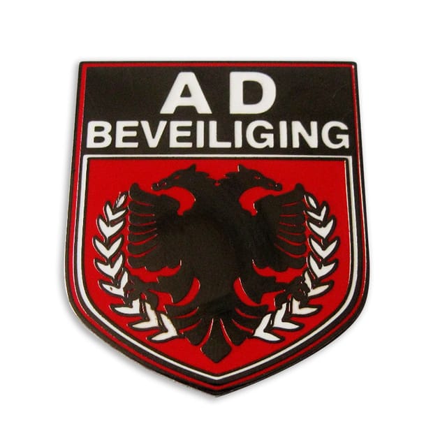 Pin in schildvorm met tekst en een zwarte adelaar op rood