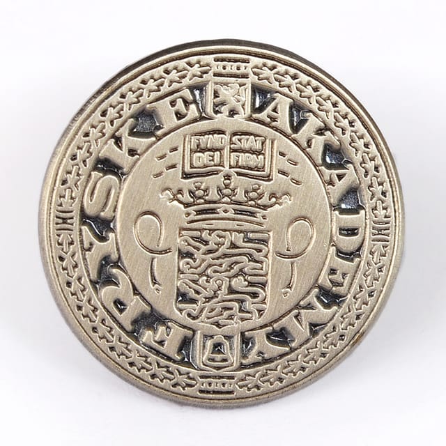 Ronde blank metalen pin met een wapen en randschrift in reliëf