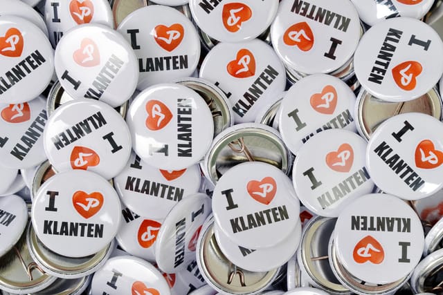 Stapel witte buttons van 25 mm met een rood hartje en tekst