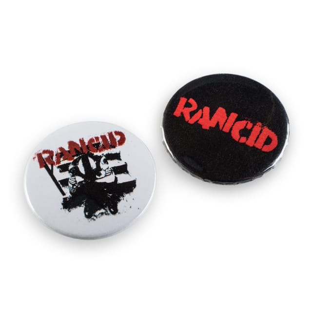 Twee ronde buttons met de bandnaam, in wit en zwart