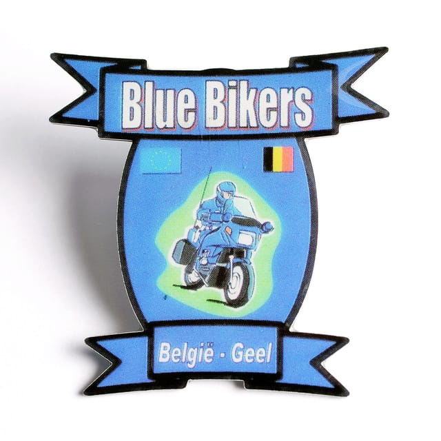 Full colour speldje in de vorm van een schild met banieren en een motorrijder