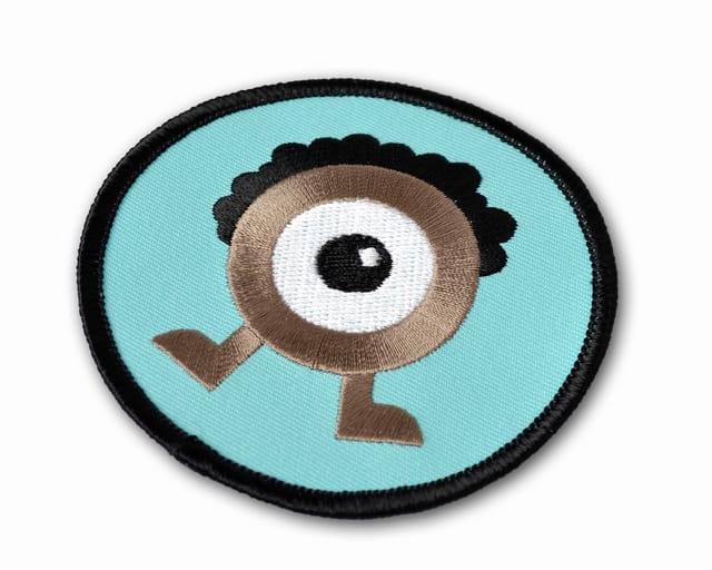 Ronde geborduurde patch met een getekend figuurtje op lichtblauw