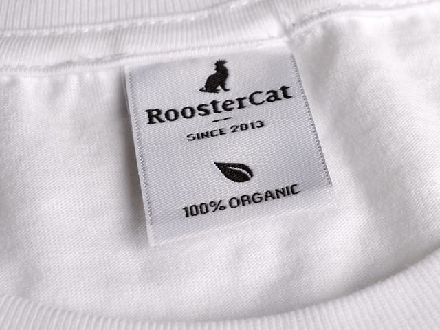 Wit geweven neklabel met logo en tekst in een T-shirt