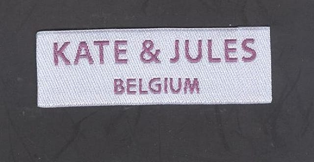 Wit geweven label met tekst in paarse letters
