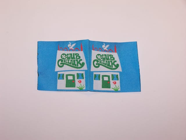 Blauw geweven label met een getekend huisje en letters