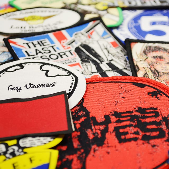 Close-up van diverse geweven patches met fijne details en letters