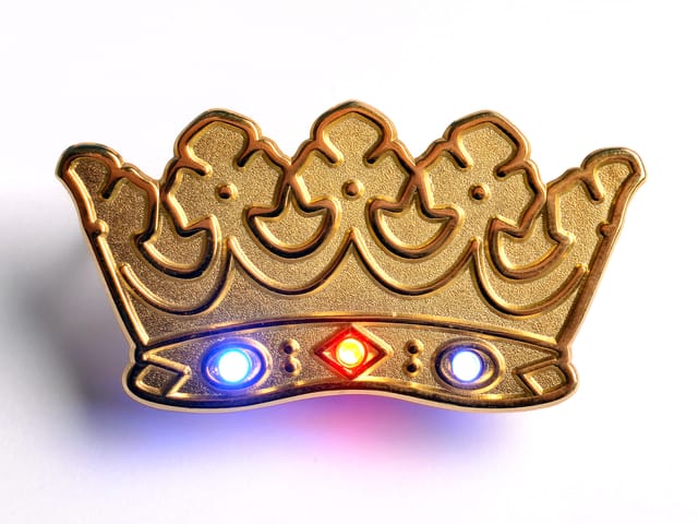 Goudkleurige pin in de vorm van een kroon met ingebouwde ledlampjes