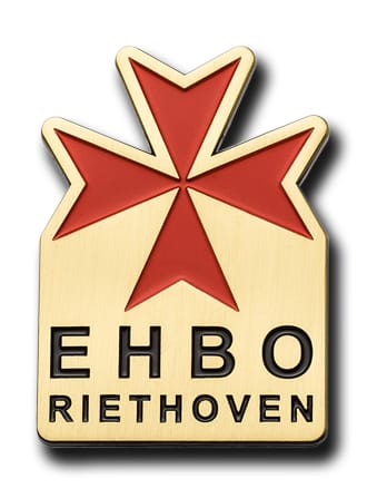 Jubileumspeldje met een rood kruis en tekst, in goud