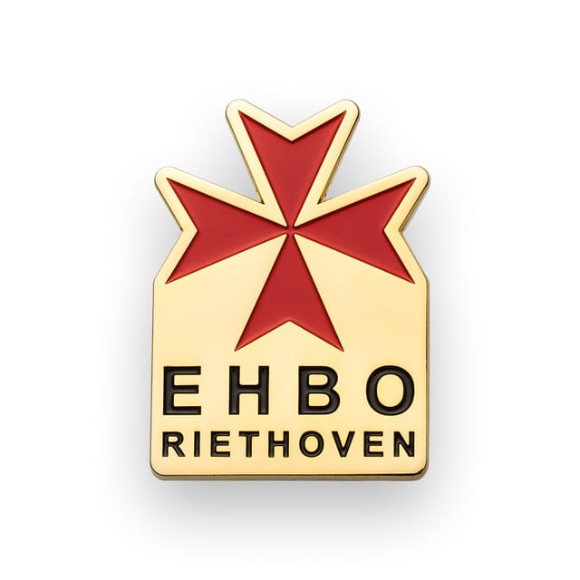 Speldje met een rood kruis en tekst, in goud