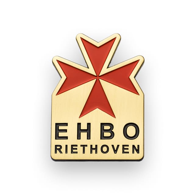 Speldje met een rood kruis en tekst, in antiek brons